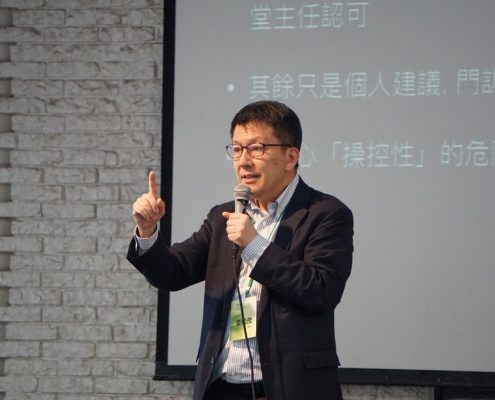 講師拿著麥克風演講